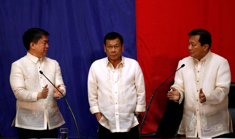 Philippine President Rodrigo Duterte stands in between Senate President Aquilino Koko Pimentel and Speaker of the House Pantaleon Alvarez before Duterte speaks during his first State of the Nation Address at the Philippine Congress in Quezon city