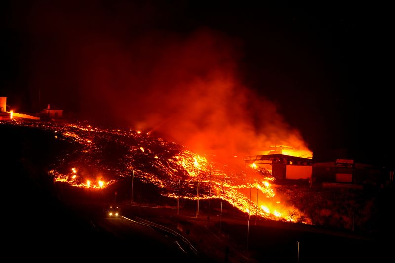 Lava burns buildings following the eruption of the Cumbre Vieja volcano, in Tacande