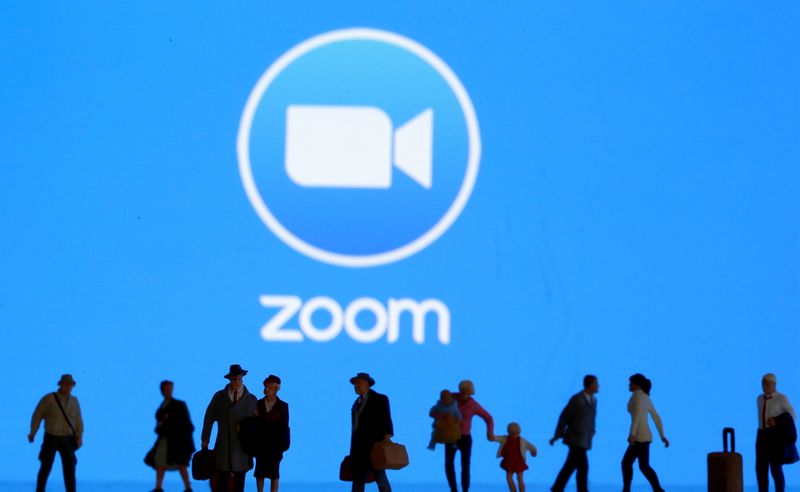 FILE PHOTO: Small toy figures are seen in front of diplayed Zoom logo