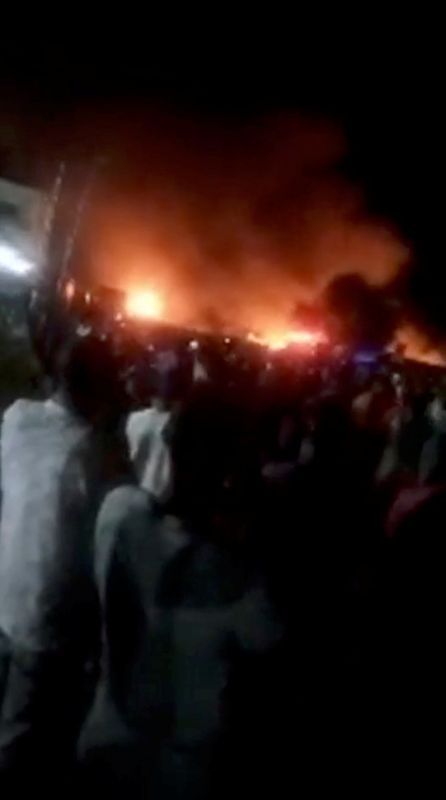 People look at fire blaze following a fuel tanker explosion in Freetown