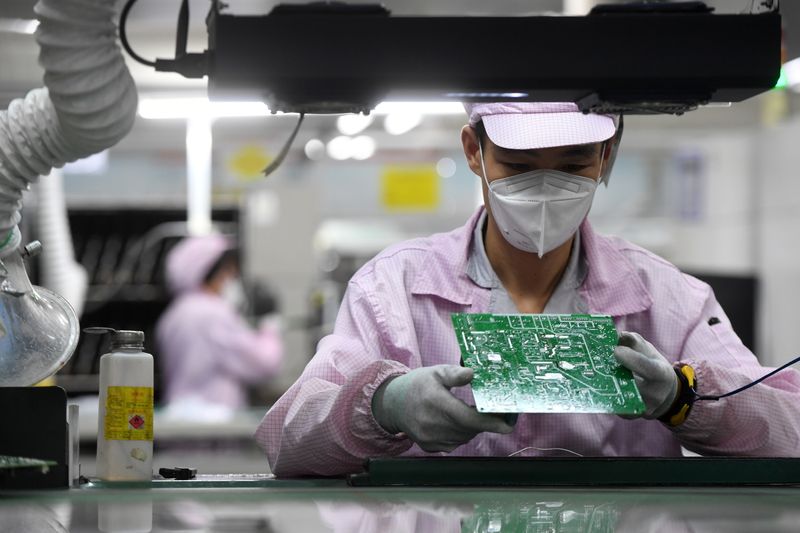 Employee inspects a circuit board at a Gree factory in Wuhan