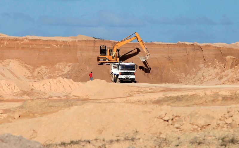 FILE PHOTO: A excavator dumps bauxite ore into a dump truck at a mine belonging to China's Bosai Minerals Group in Linden