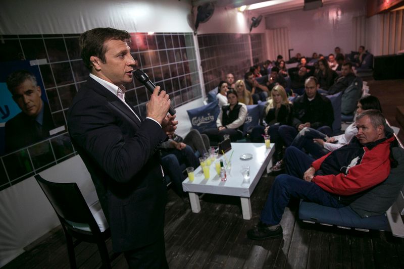 FILE PHOTO: Lawmaker Razvozov addresses Russian-speaking Israelis as he campaigns in a pub in Bat Yam