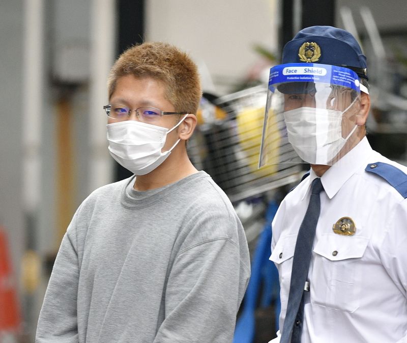 Kyota Hattori, who was arrested on suspicion of a knife, arson and acid attack incident on the Keio Line train on Halloween day, is escorted to the prosecutor's office from the Chofu police station in Tokyo