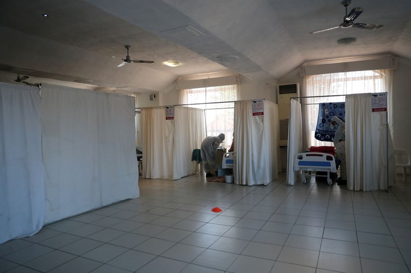 FILE PHOTO: Healthcare workers assist patients being treated at a makeshift hospital run by charity organisation The Gift of the Givers, during the coronavirus disease (COVID-19) outbreak in Johannesburg