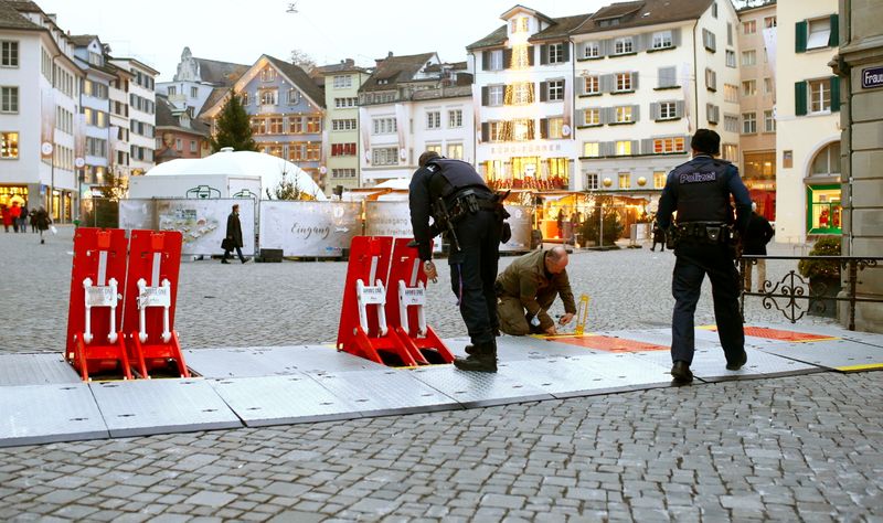 FILE PHOTO: Swiss police officers prepare mobile barriers blocking a street to protect a Christmas market, in Zurich