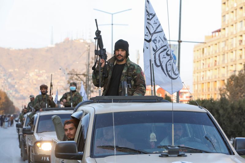 Taliban forces ride in a car during a Taliban military parade in Kabul