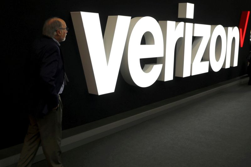 FILE PHOTO: A man stands next to the logo of Verizon at the Mobile World Congress in Barcelona