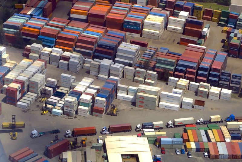 A forklift unloads shipping containers from trucks at a storage facility located near Sydney Airport