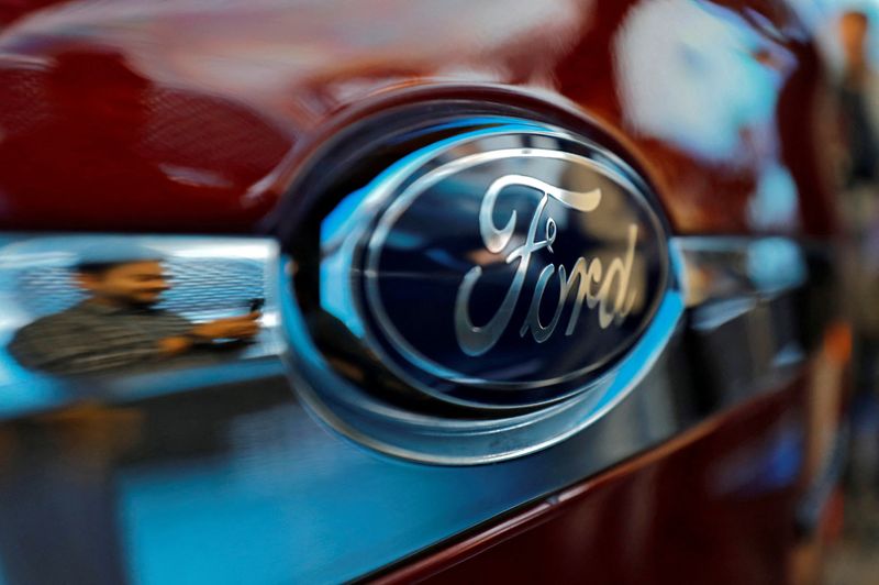 FILE PHOTO: A visitor is reflected as he takes pictures of a Ford Aspire car during its launch in New Delhi, India