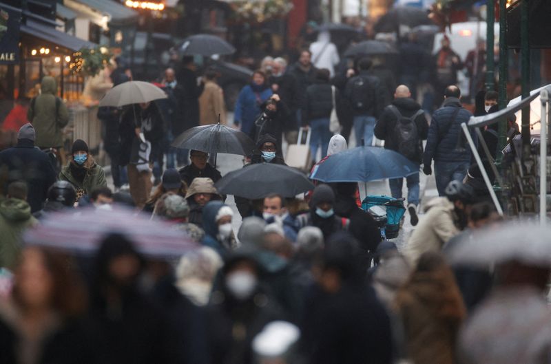 People wearing protective face masks are pictured in a street, in Paris