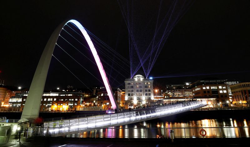 People watch the laser show from the Gateshead Millennium Bridge, organised by Newcastle City Council to celebrate the New Year in Newcastle upon Tyne