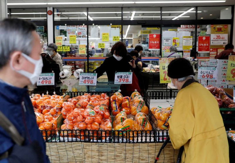 FILE PHOTO: Shoppers wearing protective face masks, following an outbreak of the coronavirus disease, are seen at a supermarket in Tokyo, Japan
