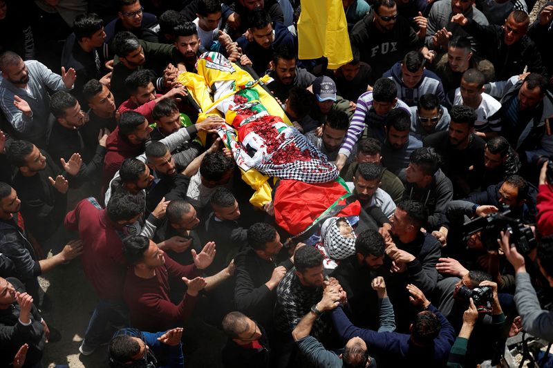 Mourners carry the body of Palestinian Ahmed Manasrah during his funeral in the Israeli-occupied West Bank