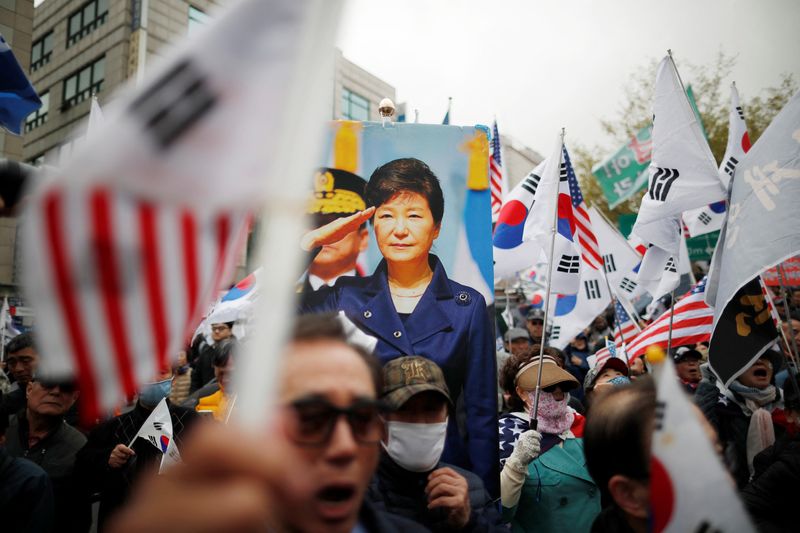 Supporters of ousted President Park Geun-hye gather outside a court after a South Korean court jailed her for 24 years, in Seoul