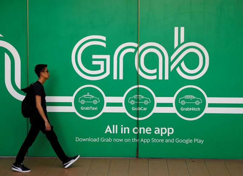 FILE PHOTO: A man walks past a Grab office in Singapore