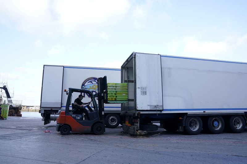 FILE PHOTO: A worker loads fish onto a truck at the Basque port of Ondarroa, amid the global outbreak of the coronavirus disease (COVID-19)