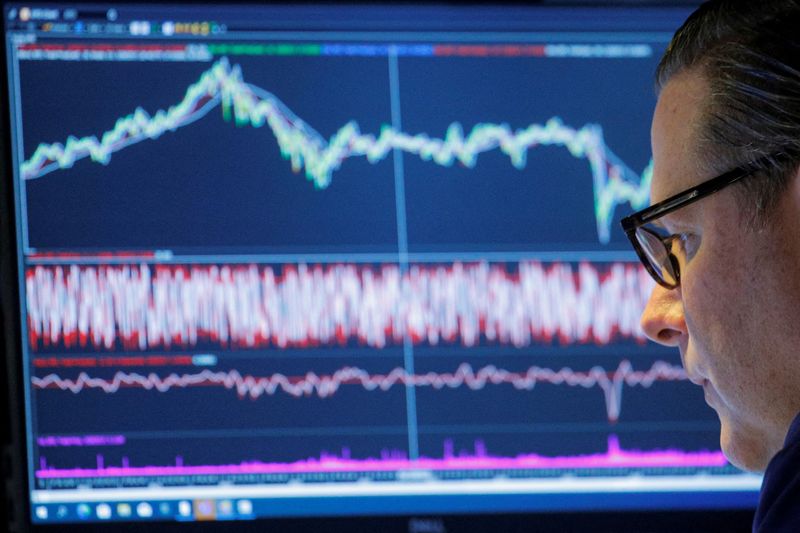 FILE PHOTO: A trader works inside a booth on the floor of the NYSE in New York