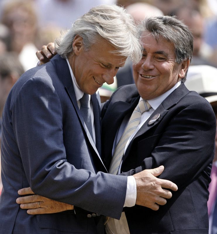 Former Wimbledon champions Bjorn Borg and Manuel Santana embrace before watching the men's singles final match at the Wimbledon tennis championships in London