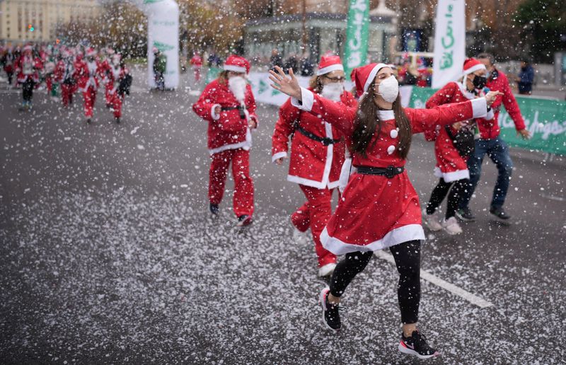 People dressed as Father Christmas get ready to run on Madrid's main avenue Paseo de la Castellana