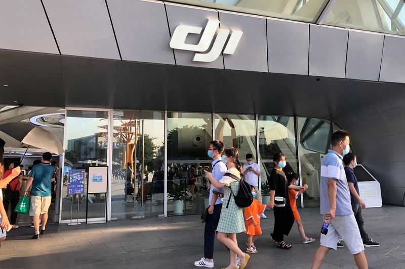 People wearing face masks following the coronavirus disease (COVID-19) outbreak walk past DJI's flagship store in Shenzhen