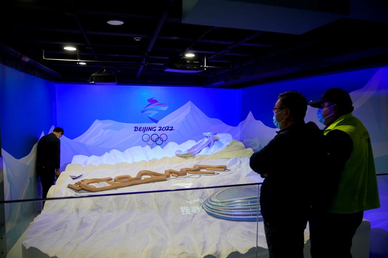 Staff members work near the emblem for Beijing 2022 Winter Olympics displayed at the Shanghai Sports Museum in Shanghai