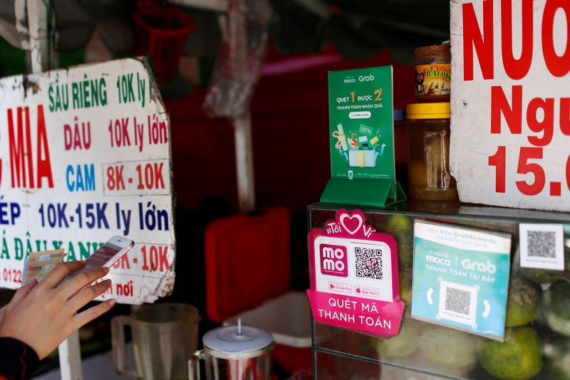 FILE PHOTO: Mobile e-payment logos are seen at a street food stall in Ho Chi Minh city in Vietnam