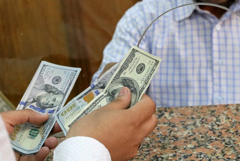 FILE PHOTO: A customer exchanges U.S. dollars to Egyptian pounds in a foreign exchange office in central Cairo, Egypt