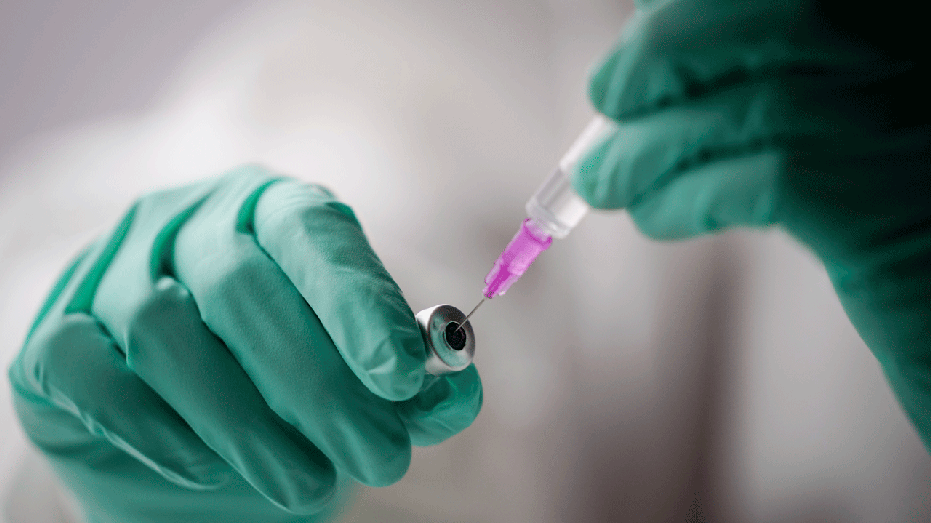 An employee draws up a syringe with the Pfizer vaccine against the coronavirus and the COVID-19 disease at vaccination bus in Berlin, Germany, Tuesday, Nov. 23, 2021. Germany battles rising numbers of coronavirus infections. (Kay Nietfeld/dpa via AP)