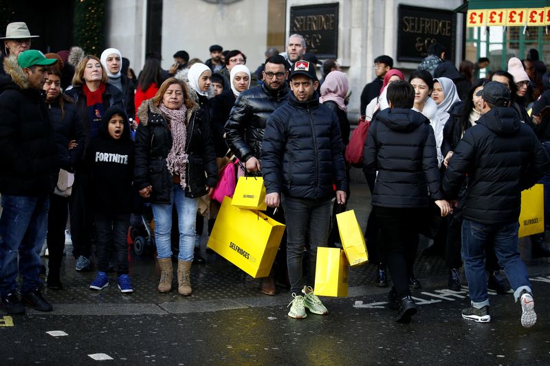 Shoppers wait to cross Oxford Street during Boxing Day sales in central London