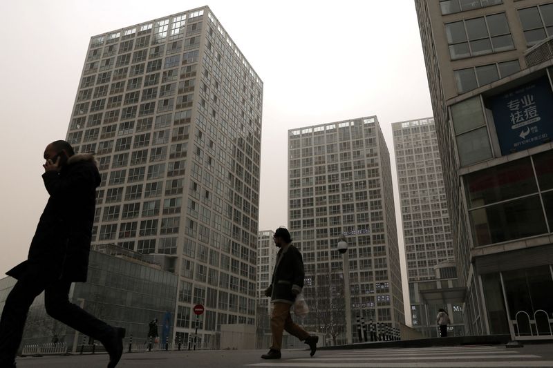 FILE PHOTO: People walk past an office and commercial complex in Beijing's Central Business District (CBD)