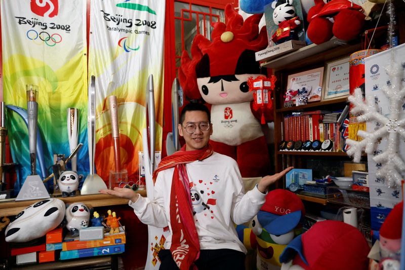 Zhang Wenquan poses with his collection of Olympic memorabilia at his home in Beijing