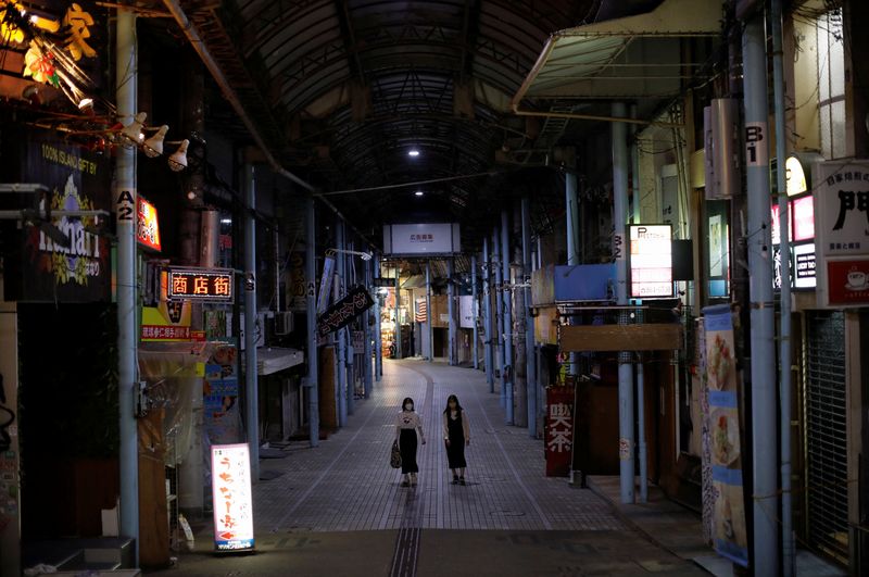 Passersby wearing protective face masks, amid the coronavirus disease (COVID-19) pandemic, walk at a shopping arcade in Okinawa