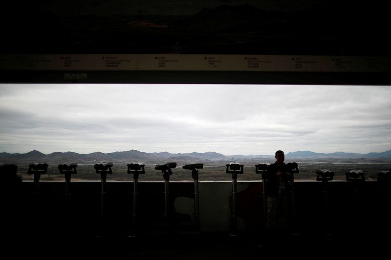 A man stands near binoculars as he tries to see North Korea's propaganda village of Gijungdong at the Dora observatory near the demilitarised zone separating the two Koreas, in Paju