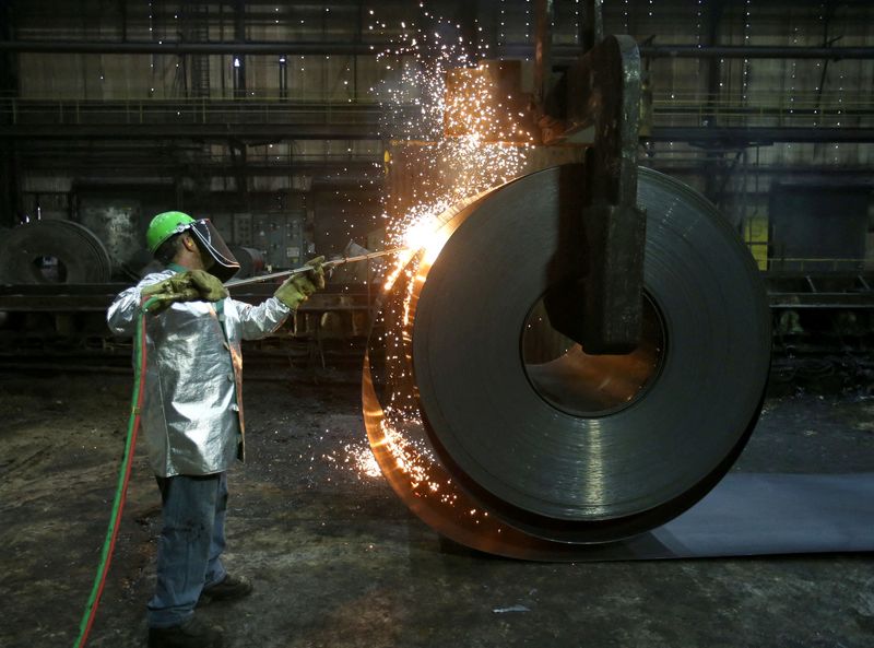 FILE PHOTO: A worker cuts a piece from a steel coil at the Novolipetsk Steel PAO steel mill in Farrell