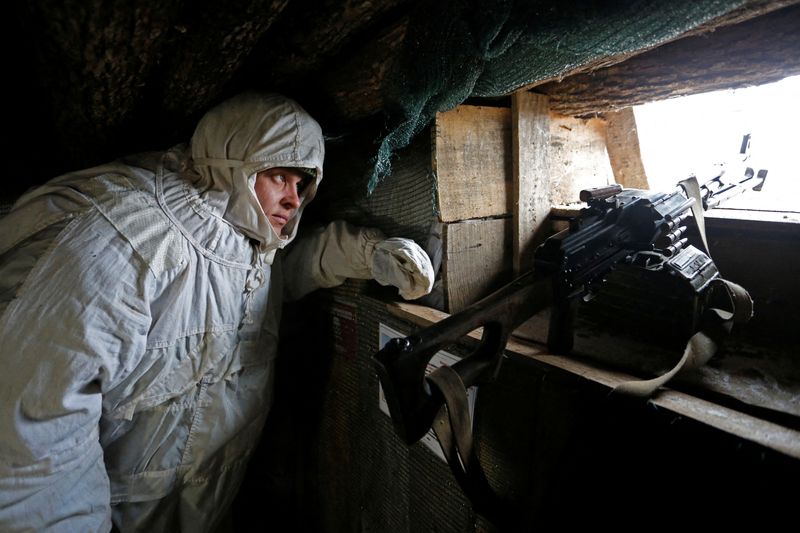 A militant of the self-proclaimed Donetsk People's Republic (DNR) observes the area at fighting positions in Donetsk region