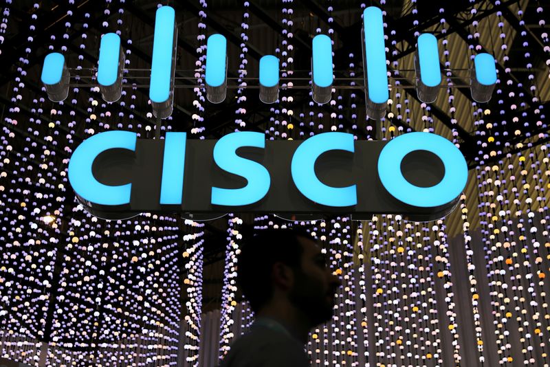 FILE PHOTO: A man passes under a Cisco logo at the Mobile World Congress in Barcelona