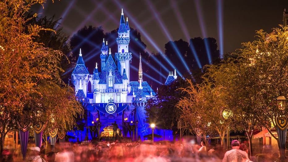 Disneyland 60th anniversary castle with people walking