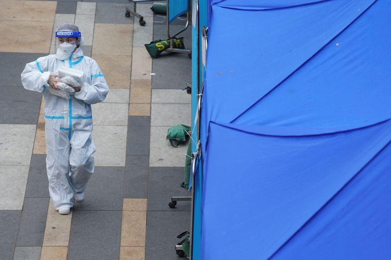 FILE PHOTO: Medical worker walks past a makeshift testing centre for the coronavirus disease (COVID-19) following the outbreak, outside a shopping mall at Sha Tin district, in Hong Kong