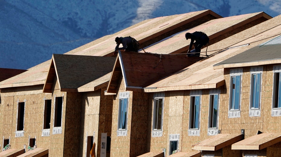Workers install roofing on an apartment complex under construction in Lehi, Utah, U.S.