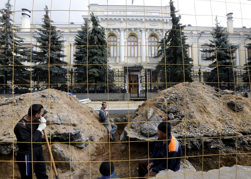 A view shows the Central Bank headquarters, with employees taking part in street repair works seen in the foreground, in central Moscow
