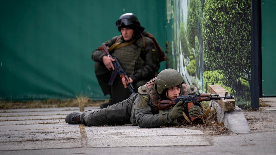 Ukrainian soldiers take positions in downtown Kyiv, Ukraine, Friday, Feb. 25, 2022. Russia pressed its invasion of Ukraine to the outskirts of the capital Friday after unleashing airstrikes on cities and military bases and sending in troops and tanks from three sides in an attack that could rewrite the global post-Cold War security order. (AP Photo/Emilio Morenatti)