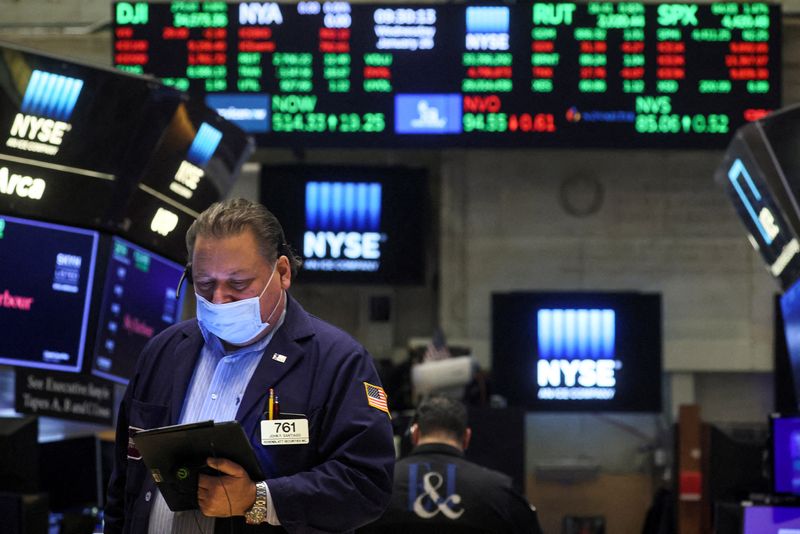 FILE PHOTO: Traders work on the floor of the NYSE in New York