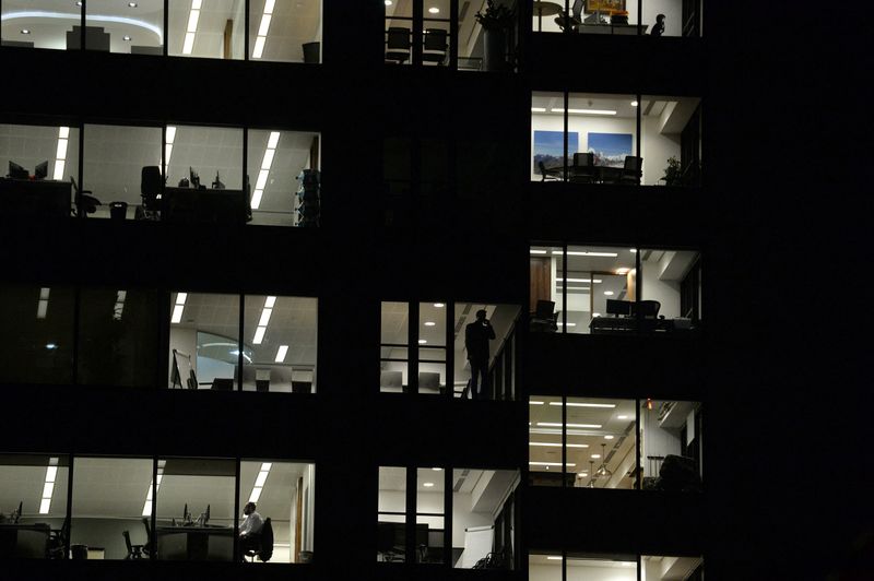 FILE PHOTO: Workers continue working into the night in the City of London