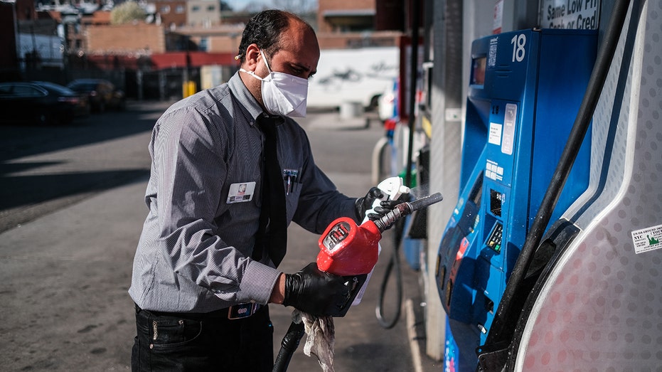 Cashier Abdul Kuddus cleans due to the outbreak of the coronavirus disease (COVID-19) at a Mobil gas station on Atlantic Avenue in the Brooklyn borough of New York City, March 26, 2020. 