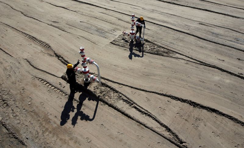 FILE PHOTO: Employees work at well pad of Rosneft-owned Prirazlomnoye oil field outside Nefteyugansk