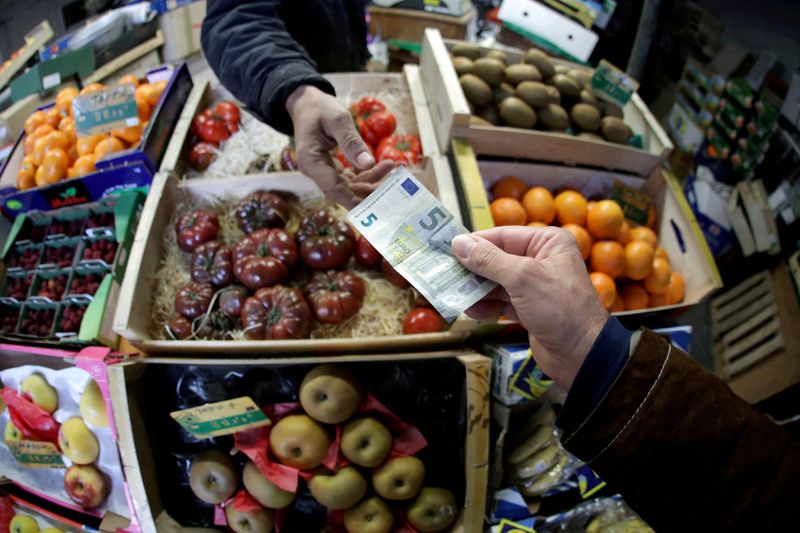 FILE PHOTO: FILE PHOTO: A shopper pays with a Euro bank note in a market in Nice
