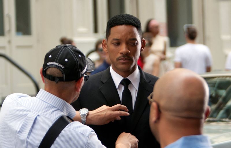 FILE PHOTO: Actor Will Smith has his tie adjusted between takes on the set of 