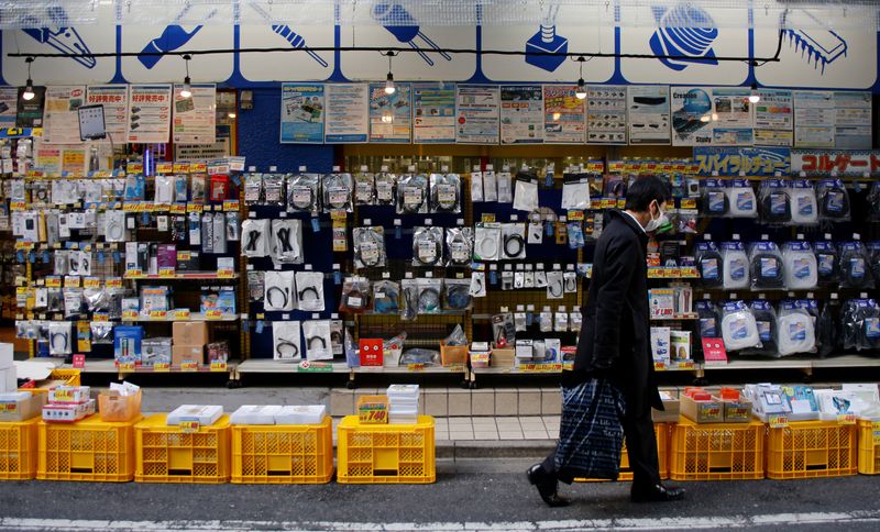 A man walks in front of an electronics store in Tokyo