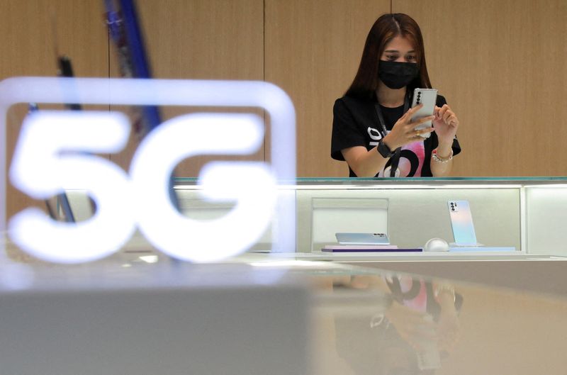 FILE PHOTO: A salesperson at a telecommunications store uses a phone in Kuala Lumpur